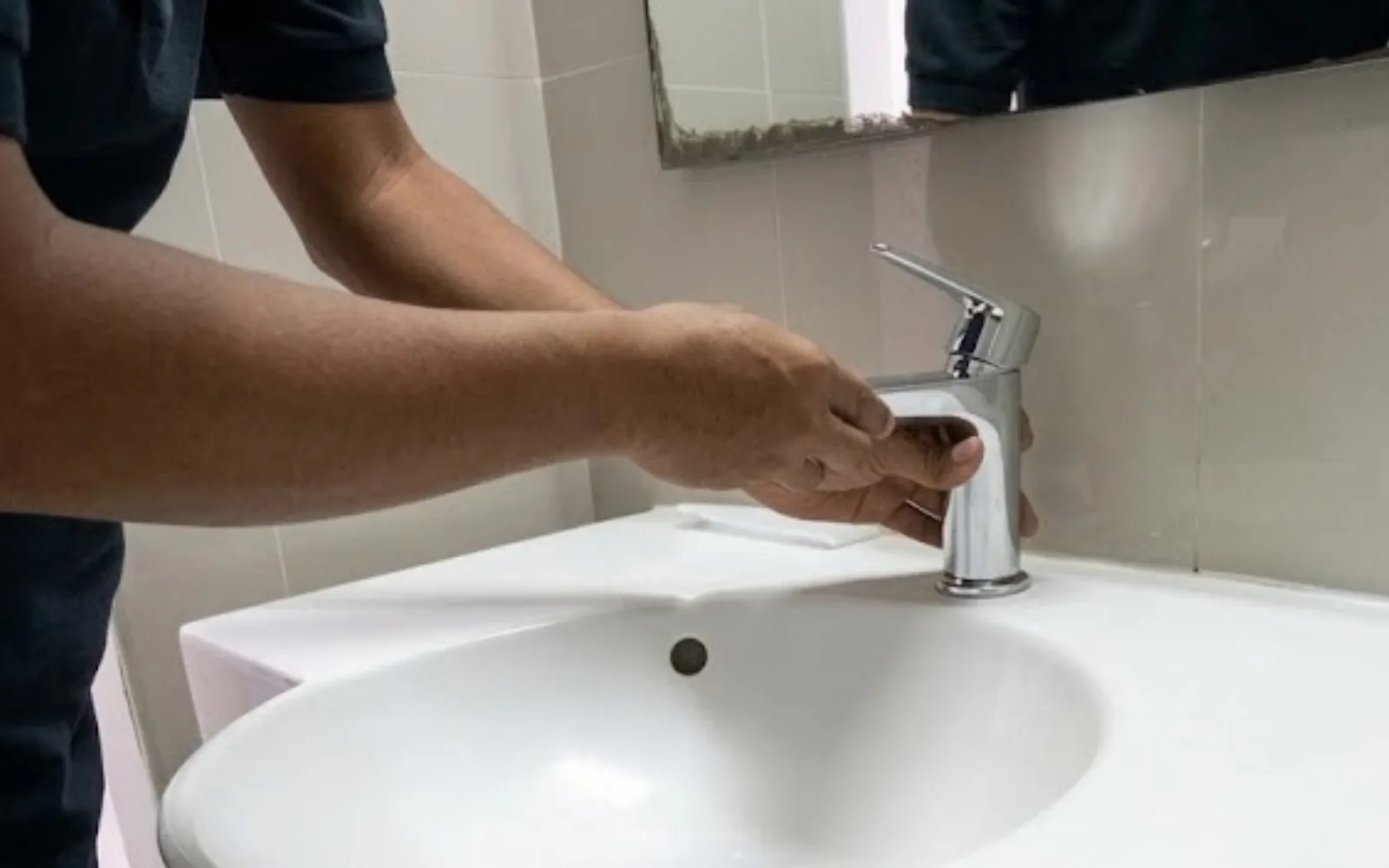 Plumber repairing a kitchen faucet at the sink