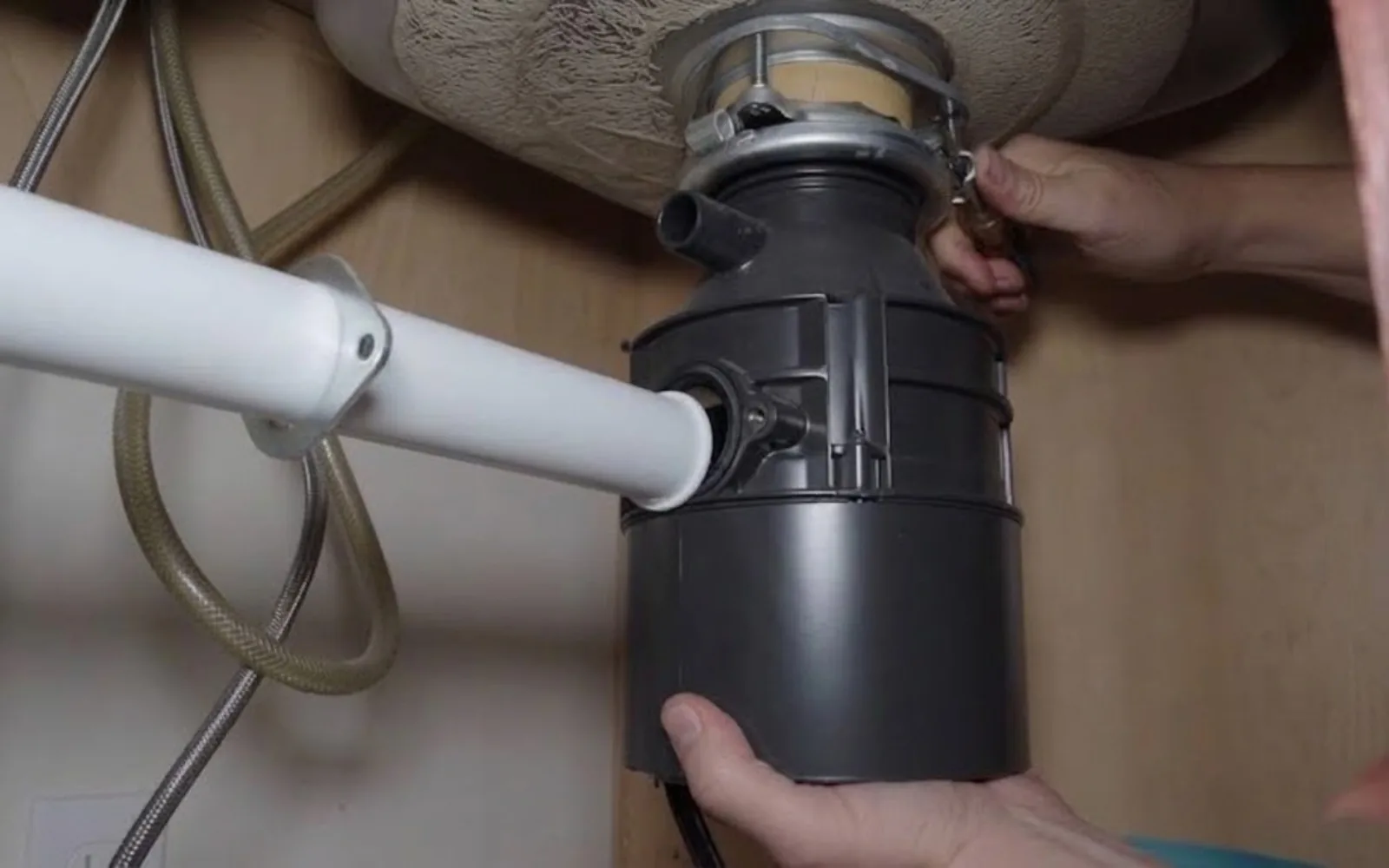 Garbage disposal unit being installed under a kitchen sink