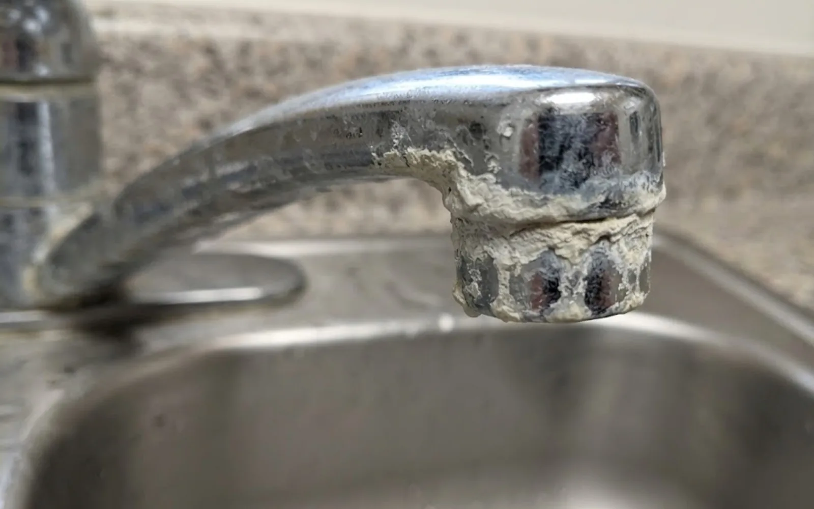 Mineral scale buildup on a faucet aerator caused by hard water