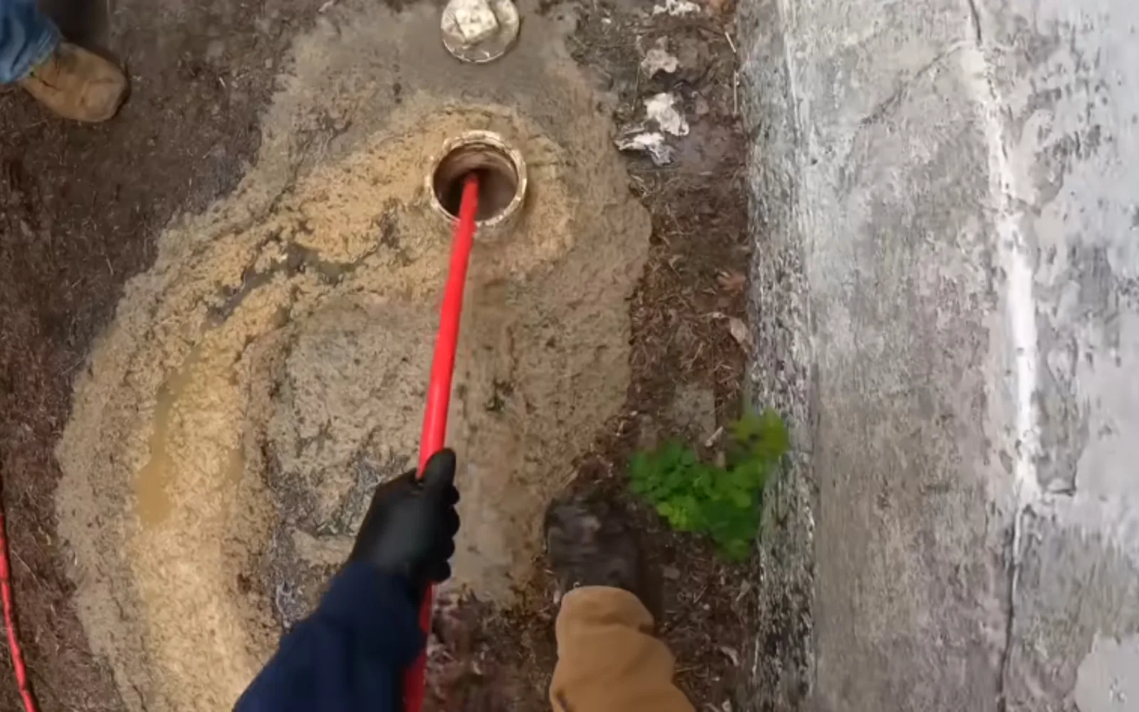 Plumber accessing an exterior sewer cleanout point for a camera inspection